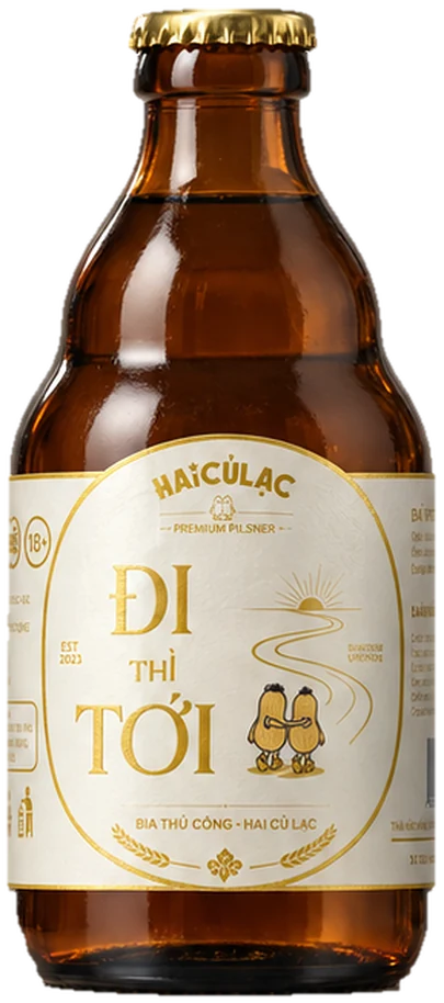 Đi Thì Tới 330 ml craft bottle, brown glass, gold cap, cream and gold label, two peanuts with their backs turned, walking toward the road and the sun